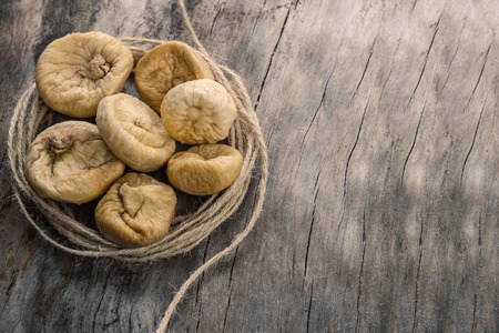 Dried figs in twine on grey wooden table.の写真素材