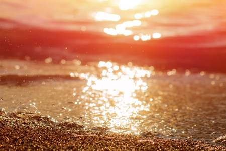 Wet sea sand on beach against background beautiful golden sunset.の写真素材