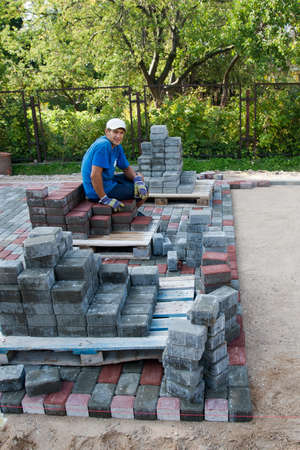 Worker resting at the end of new cobbled streetの写真素材