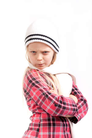 angry little girl in white hat posing over white bacgroundの写真素材