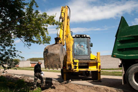 new street construction with excavator, dump truck and works manager