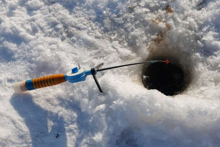 Winter fishing rod and hole in the iceの写真素材