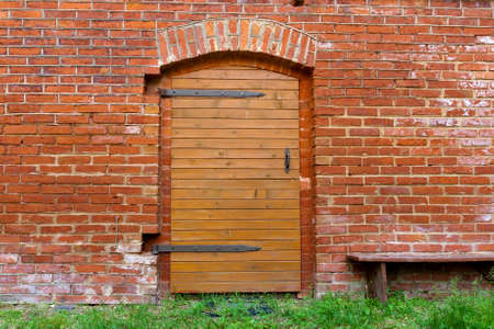Big wooden doors in red brick wallの写真素材