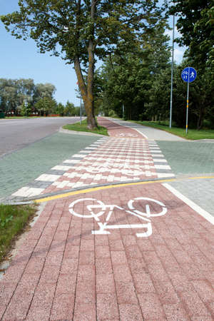 paved bicycle path crosses the streetの写真素材