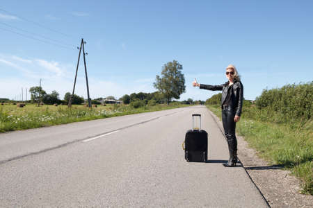 lonely hitchhiker at rural roadsideの写真素材