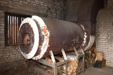 old rusty metal industrial oven heated with woodの写真素材