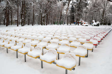 snow-covered seats in the park after the snow stormの写真素材
