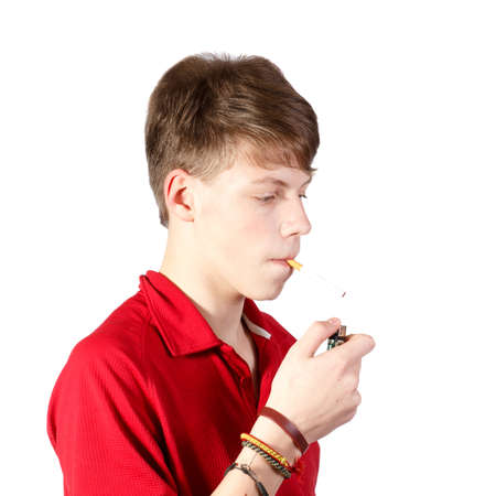 a teenage boy trying to smoke a cigarette against white backgroundの写真素材