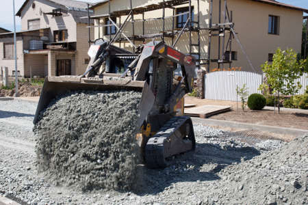 small excavator working on construction site, build new streetの写真素材