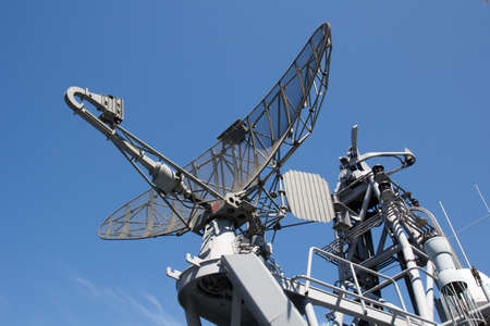 Radar on military ship against blue sky
