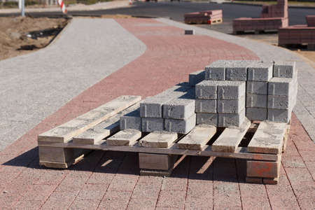 A bunch of road construction bricks placed on a wooden supporterの写真素材