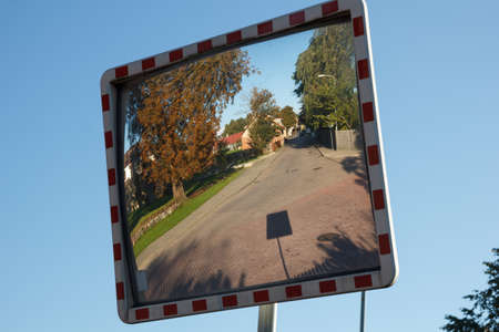 A convex mirror street sign on a roadの写真素材