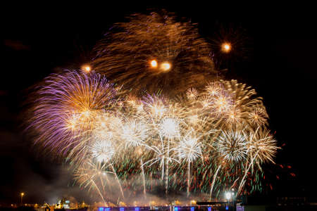 Bright and colorful firework explosions on dark backgroundの写真素材