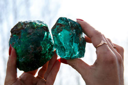 A woman holding two raw glass rocksの写真素材
