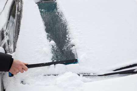 cleaning snow from carの写真素材