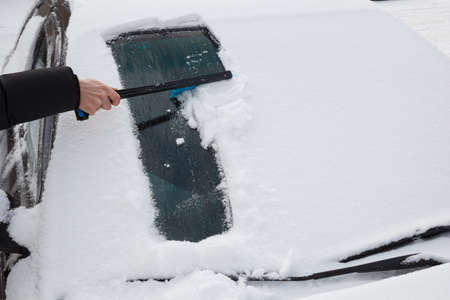 cleaning snow from carの写真素材