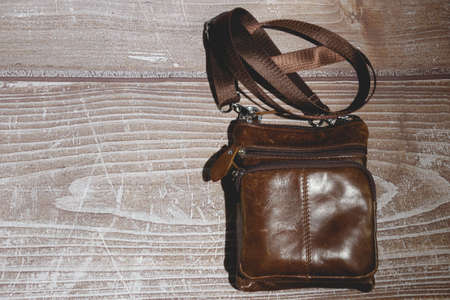 mens leather shoulder bag on wooden background