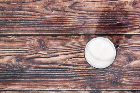 glass of milk on wooden background from aboveの写真素材