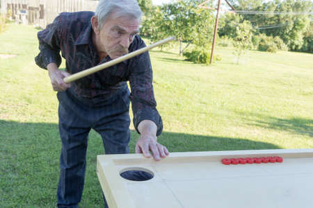 Man playing Novuss in outdoors. Novuss is a national sport in Latvia similar to pocket billiards or...