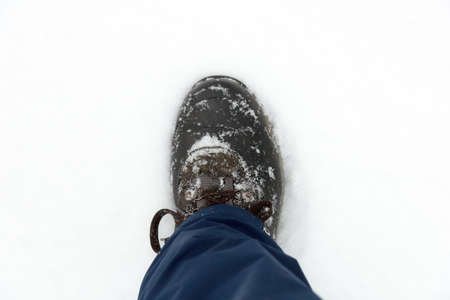 Closeup of mens hiking boots in the fresh snow.の写真素材