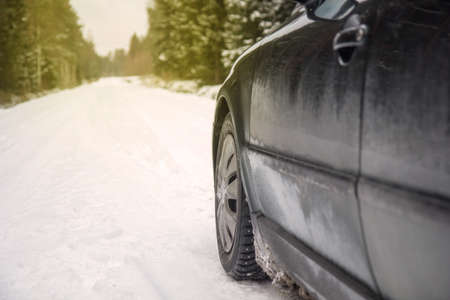 Winter Driving. Driving car through forest by small snowy road.の写真素材