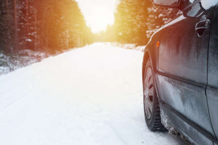 Winter Driving. Driving car through forest by small snowy road.の写真素材