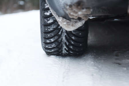 Closeup of car tire in winter on the road covered with snow