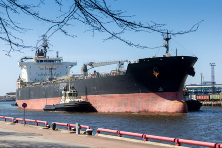 Three tug-boots pushing big ship in to port