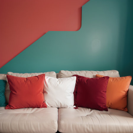 Three red decorative pillows on a contemporary sofa.の素材