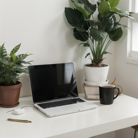Close-up of open laptop on white table. Nearby is a tablet computer, a smartphone, paper graphics, pencil holder. In the backgrounの素材