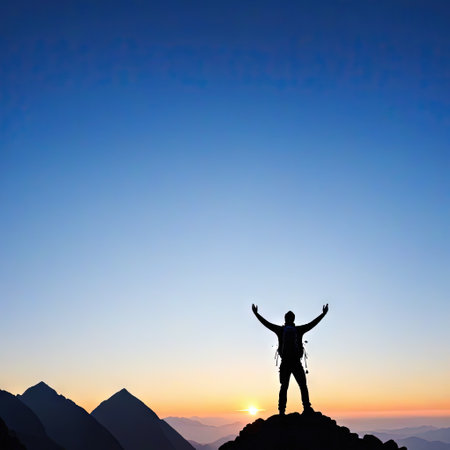 A silhouette with raised hands standing on the top of a mountain at sunrise with a beautiful mountain view representingの素材