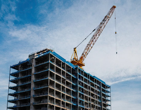 Crane and building under construction against blue sky, Moscow, Russiaの素材