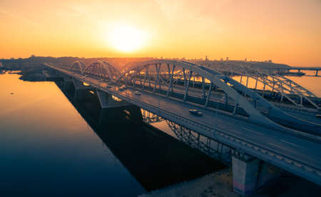 Darnitskiy bridge across Dnepr river against sunset sky. Kiev, Ukraineの写真素材