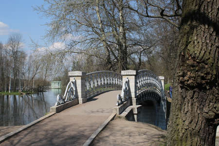 Gatchina, Russia - MAY 3, 2016: Beautiful stone footbridge with a cast-iron fence. Pond in Gatchinaのeditorial素材