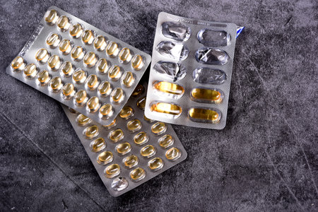 Yellow soft shell vitamin D capsules. Vitamin D yellow pills on a dark background. medicine concept.