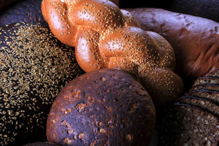 Still life with different types of bread: black, rye, white bread, bread with seeds. bread and wheat...