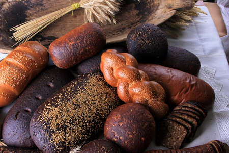 Still life with different types of bread: black, rye, white bread, bread with seeds. bread and wheat...