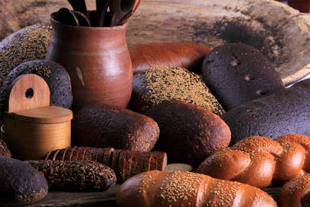 Still life with different types of bread: black, rye, white bread, bread with seeds. bread and wheat...