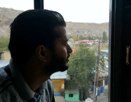 AcSelf Isolation person holed up inside, looking out the window during Coronavirus lockdown. Lockdown, coronavirus pandemic has largely put a halt on daily life of people.の写真素材