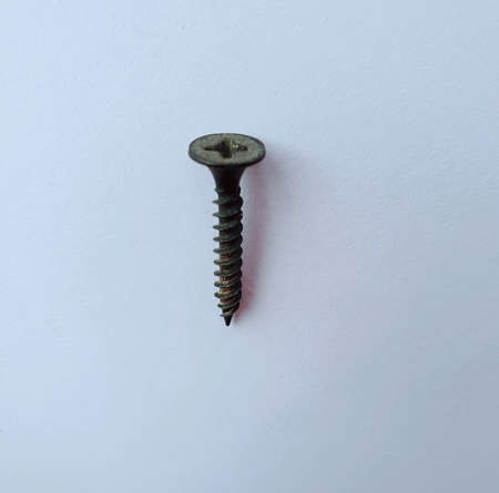 A black iron screw keel lies on white paper.