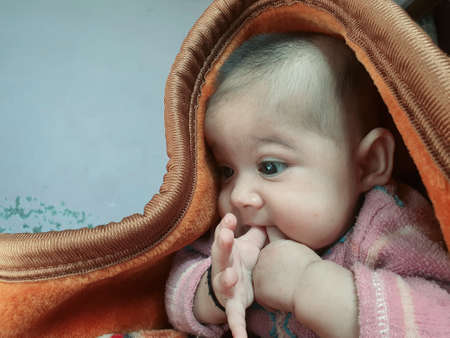 Smiling kid photographs at home under blanket looks beautiful. Digital and 4k photos of child.の写真素材
