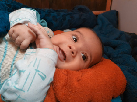 Smiling kid photographs at home under blanket looks beautiful. Digital and 4k photos of child.