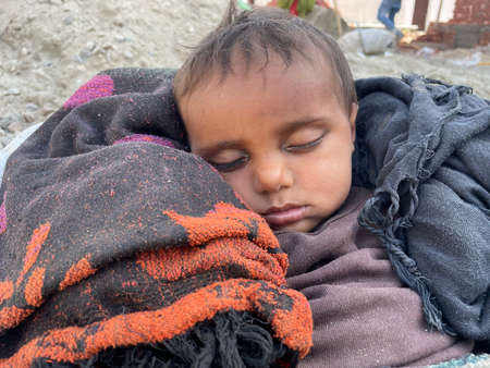 Jammu India 02 04 2022. Adorable little child sleeping in the bucket. Quiet sleep quiet starry at day.のeditorial素材