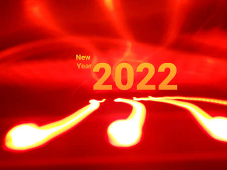Light painting long exposure photography. Year 2022 out in multicolor red numbers against...
