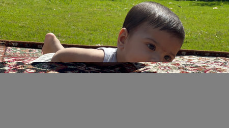 A newborn boy in an open air park smiling, looks beautiful with an Indian face. A healthy boy child.の写真素材