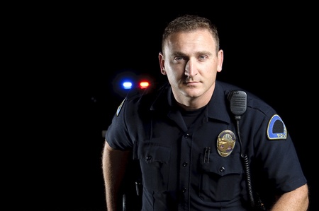a police officer standing in the night during a patrol shift. 