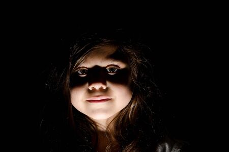 a little girl in a low key setting portrait.