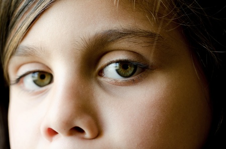 A close up of a 7 year old girl.  The focus was put on her left eye. The right eye was left slightly ourof focus on purpose. の写真素材