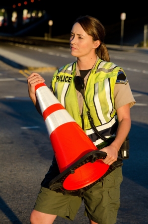 a police officer carrying a cone during a traffic control shift  の写真素材