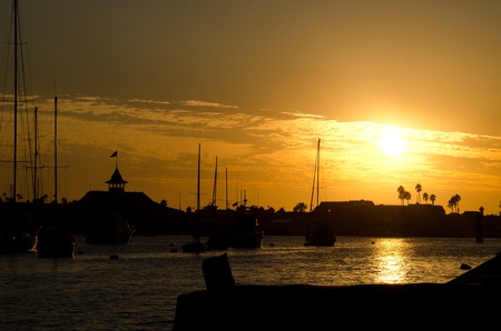 The sun setting in the harbor in Newport Beach,CA in October の写真素材